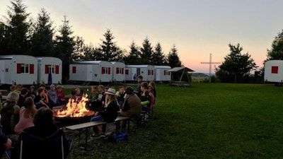 Kinder sitzen am Lagerfeuer im Bauwagencamp Hoheneiche